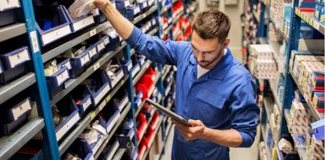 Technicien consultant un inventaire de pièces dans un magasin industriel